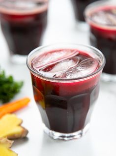 several glasses filled with different types of fruit and veggies next to each other