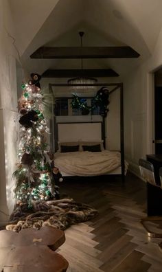 a bedroom decorated for christmas with lights on the tree