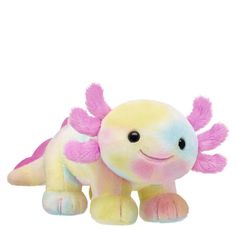 a small stuffed animal with pink and yellow wings on it's back, sitting in front of a white background