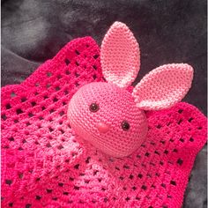 a pink crocheted bunny on top of a blanket