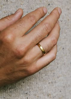 a man's hand with a gold ring on it