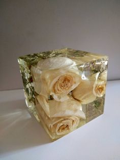 a glass block with flowers on it sitting on a table