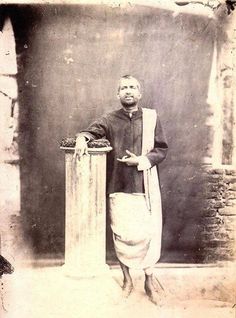 an old black and white photo of a man standing next to a trash can