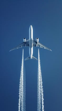 an airplane is flying in the air with four jets trailing behind it and leaving trails