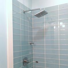 the shower head is mounted on the wall above the toilet and it's tile