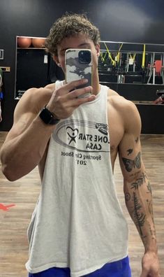 a man taking a selfie in a gym with his cell phone up to his face