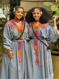 two women in dresses standing next to each other