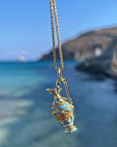 Please be advised that this order is MADE TO ORDER. Please allow 6-8 weeks for production. Channel your inner ancient Greek Goddess with these handcrafted pendants.  Handcrafted of solid 14 karat solid gold, this pendant features a Grecian vase with baked enamel blue & white finishes and filigree work.  Attached to a 20 inch curb link cabin.  Weighs 7 grams.  Measures just over one inch long. The Grecian Vase or Amphora is typically a one or two handled vessel used to transport olive oil and win Grecian Vase, Greek Amphora, Vase Necklace, Amphora Vase, Ancient Greek Goddess, Perfume Necklace, Ancient Greek Jewelry, Icon Jewelry, Faberge Jewelry