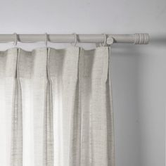 a white curtain hanging on the side of a window