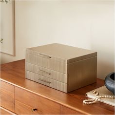 a brown box sitting on top of a wooden dresser