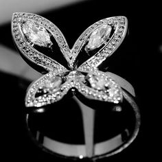 a ring with diamonds on it sitting on top of a black surface in front of a white background