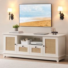 a white entertainment center with wicker baskets on it