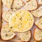 a box filled with slices of bread covered in cheese and seasoning sitting on top of a table