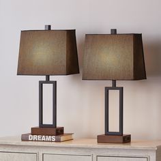 two lamps sitting on top of a dresser next to each other