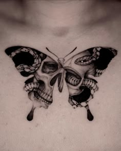 a man's chest with a butterfly and skull tattoos on the chest, which are black and white