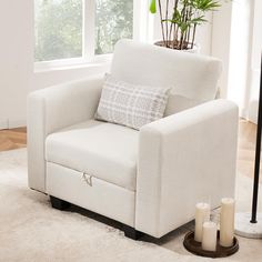 a white chair sitting on top of a rug next to a lamp and a window