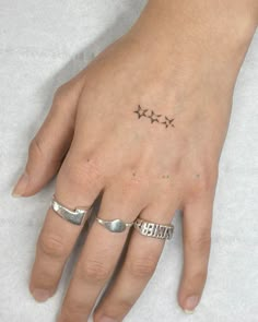 a woman's hand with three stars tattooed on it