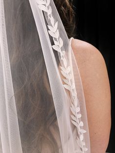 the back of a bride's veil with leaves on it