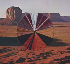 an image of a red, white and blue color wheel in the middle of desert