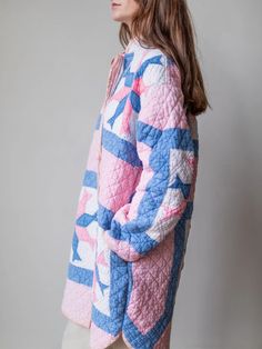 a woman wearing a pink and blue quilted jacket