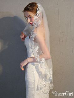 a woman in a white wedding dress and veil