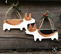 two ceramic foxes hanging from twine on wooden planks