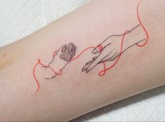 a tattoo on the arm of a person with a dog's paw and hand