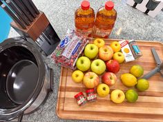 apples, oranges and other fruit on a cutting board next to a toaster