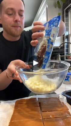 a man mixing food in a bowl on top of a table with chocolate bars and other ingredients