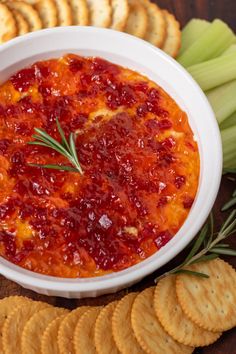 a white bowl filled with cranberry sauce surrounded by crackers