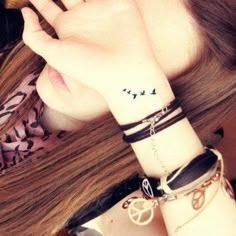 a woman wearing a bracelet with birds on her wrist and the word love written in black ink