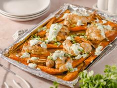 a sheet pan filled with shrimp and sweet potato wedges covered in sour cream sauce