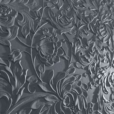 an intricately designed wallpaper with flowers and leaves on it's surface, in grey