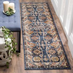 a blue runner rug on the floor next to a candle