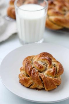 a white plate topped with pastry next to a glass of milk