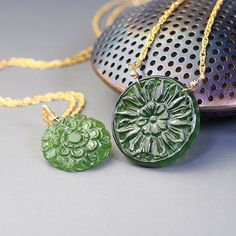 Unique, carved gemstone medallions star in these  gold filled necklaces. Made with delicate woven chain these necklaces feature unique, carved with beautiful floral designs, coin shaped, green Antigorite serpentine. Four available, two with  19mm medallions (options A and B) and two with 25mm medallions  (Option C and D).  Each one of these necklaces looks stylish and elegant, each makes make a statement. These necklaces are to be purchased separately.  Completed with gold filled, lobster claw c Spiritual Carved Medallion Jewelry, Handmade Yellow Gold Jade Necklaces, Handmade Yellow Gold Jade Necklace, Carved Amulet Necklace With Round Pendant, Carved Round Pendant Amulet Necklace, Carved Yellow Gold Necklace, Carved Yellow Gold Necklace For Gift, Carved Yellow Gold Necklace Perfect For Gift, Artisan Carved Round Jewelry