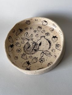 a white bowl with black designs on it