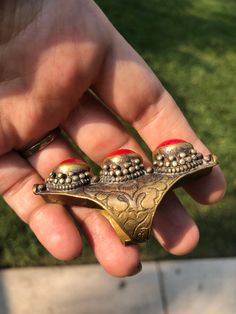 Beautiful vintage tribal saddle full finger ring Red gemstones or glass? Brass intricate carving Adjustable between sizes 9- 11. This is a gorgeous and very unique finger ring. There are three round cut cabochons and I am not sure what they are made of, they could be gemstone or they could be glass. The ring itself appears to be brass and someone could probably give it a good polishing if desired although I think it adds to the character the way it is. The ring Can fit anywhere from a size 9 thr Unique Ceremonial Toe Ring Jewelry, Unique Ceremonial Toe Ring, Unique Metal Rings For Festivals, Unique Carved Ring Jewelry, Bohemian Carved Jewelry For Rituals, Bohemian Carved Brass Jewelry, Unique Ceremonial Bronze Rings, Unique Carved Ceremonial Jewelry, Ceremonial Hand Cast Unique Jewelry