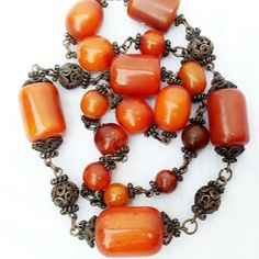 Beautiful Vintage Baltic Amber Barrel Bead & Copper With A Gold Patina Necklace. Large Authentic Baltic Amber Barrel Beads Graduated Into Smaller, Round Amber Beads, & Copper Filigree Spacer Beads With A Dark Gold Patina In Between. Measures Approximately 14" Long. No Clasp, But One Could Be Easily Added. The Largest Bead Is About 1.25" X 1". The Smallest Bead Is About .5" Round.Weighs Around 150 Grams. In Excellent Condition! Rare Vintage Find! Bohemian Orange Single Strand Beads, Elegant Orange Necklaces With Polished Beads, Vintage Orange Beaded Chain Necklace, Elegant Orange Carnelian Beaded Necklace, Vintage Orange Beaded Necklace, Elegant Orange Beaded Necklaces With Gemstone Beads, Elegant Orange Gemstone Beaded Necklaces, Elegant Orange Gemstone Beads Necklace, Antique Orange Jewelry With Round Beads