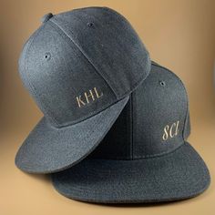 two hats with the letters khl and scc on them sitting next to each other