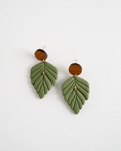 the green leaf earrings are made with wood and leather