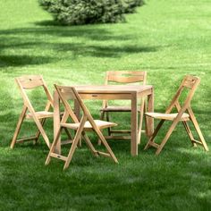 a wooden table and chairs sitting in the grass