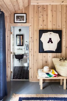 a bathroom with wood paneling and a white shirt hanging on the wall next to a wooden bench