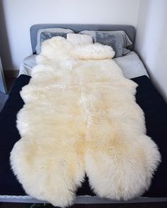 a white sheepskin rug on top of a bed