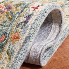 a close up of a rug on the floor with a wooden floor in the background