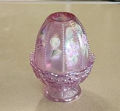 a pink glass vase sitting on top of a counter