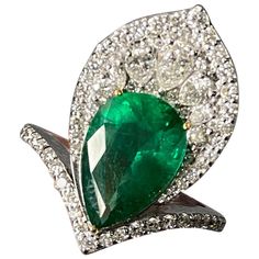 A beautifully designed cocktail ring, with 3.73 carat pear shape Zambian Emerald surrounded with VS quality, colorless Diamond (pear shape and brilliant cut) - all set in solid 18K White Gold. The Emerald is of very high quality, great luster, transparent, and has an ideal vivid green color. Currently sized at US 6, can be resized. Video available. Free shipping provided, returns accepted! Stone Details: Stone: Zambian Emerald Carat Weight: 3.73 Carats Diamond Details: Total Carat Weight: 1.22 carat Quality: VS , G/H 18K Gold: 6.76 grams Luxury Pear-shaped Diamond Emerald Ring, Luxury Pear-shaped Emerald Ring With Prong Setting, Gia Certified Pear Diamond Ring, Gia Certified Teardrop Diamond Ring For Formal Occasions, Gia Certified Pear-shaped Diamond Ring, Formal Gia Certified Teardrop Diamond Ring, Formal Pear-shaped Brilliant Cut Emerald Ring, Green Pear-shaped Diamond Ring, Elegant Emerald Diamond Pear-shaped Ring