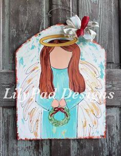 a wooden plaque with an angel holding a wreath on it's head and wearing a halo