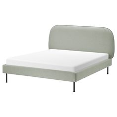 a bed with a white mattress and green headboard