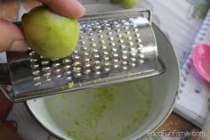 a person grating an apple with a grater